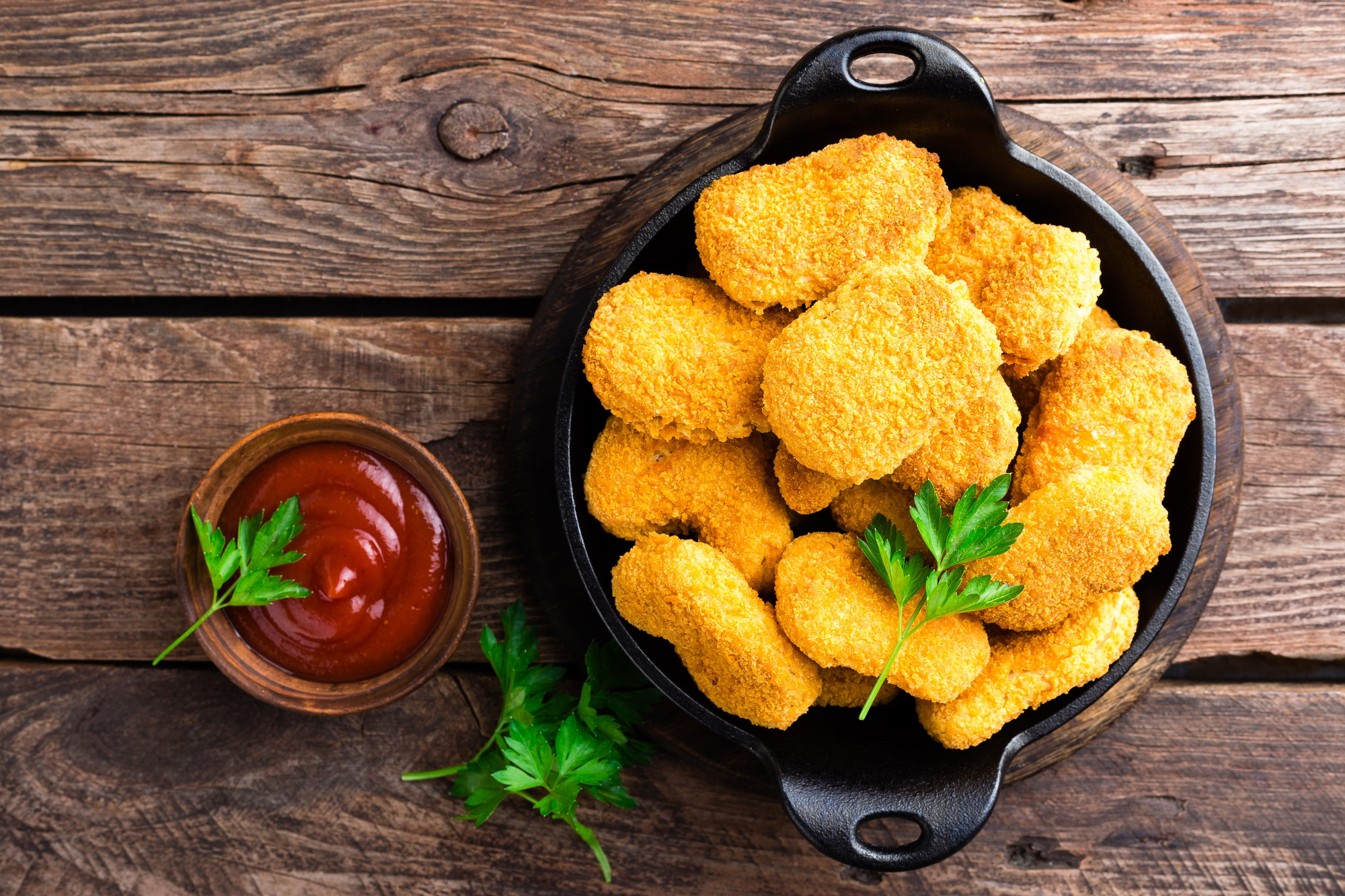 Nuggets. Chicken nuggets with ketchup on wooden table. Fast food